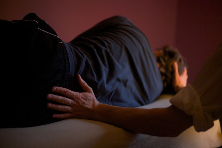 hands touching spine and head